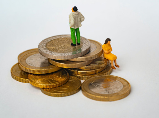 Stack of coins with man looking to the sky and a woman sitting on the coins appearing to be concerned.