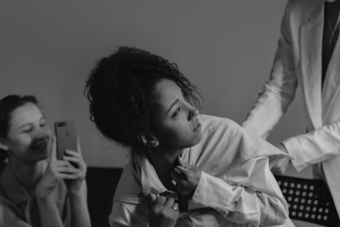 A girl being yelled at by her boss as another girl videos the altercation, filming it on her phone. This is a display of bullying.